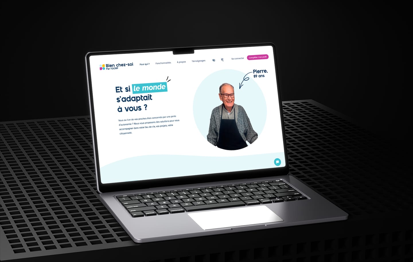 Accueil du site vitrine Bien chez-soi par l'OCIRP sur un ordinateur portable : titre « Et si le monde s'adaptait à vous ? », portrait souriant de Pierre, 89 ans, et bouton « Compléter mon profil ».